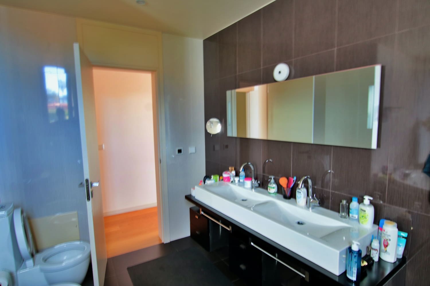 BATHROOM with two hand basins and a toilet seat