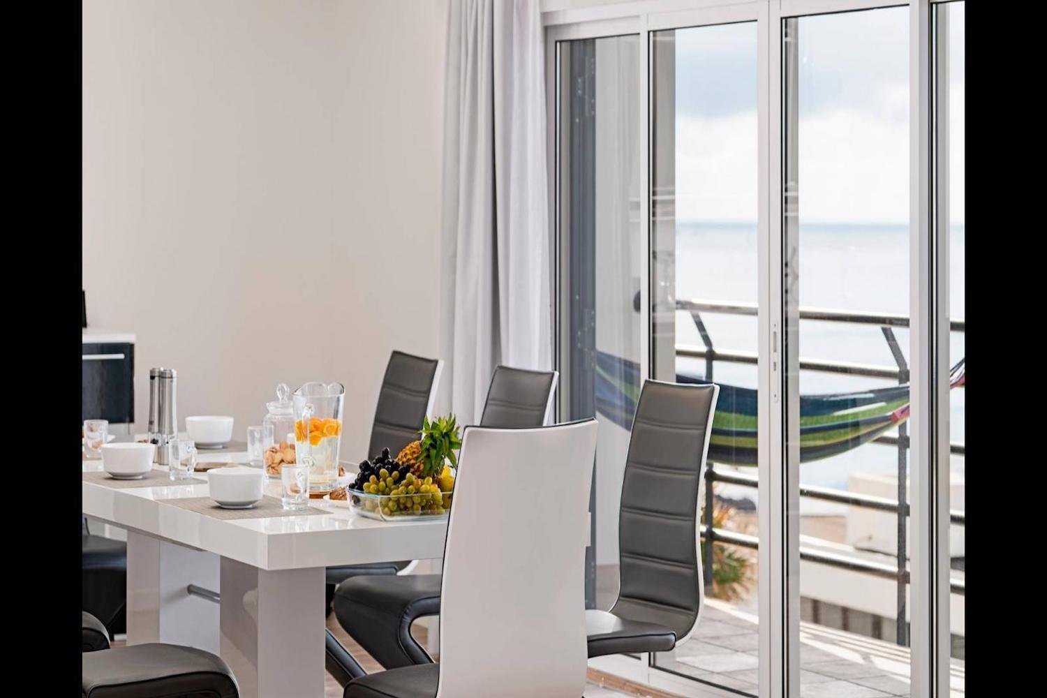 Dining room with table an chairs and view of the sea and veranda