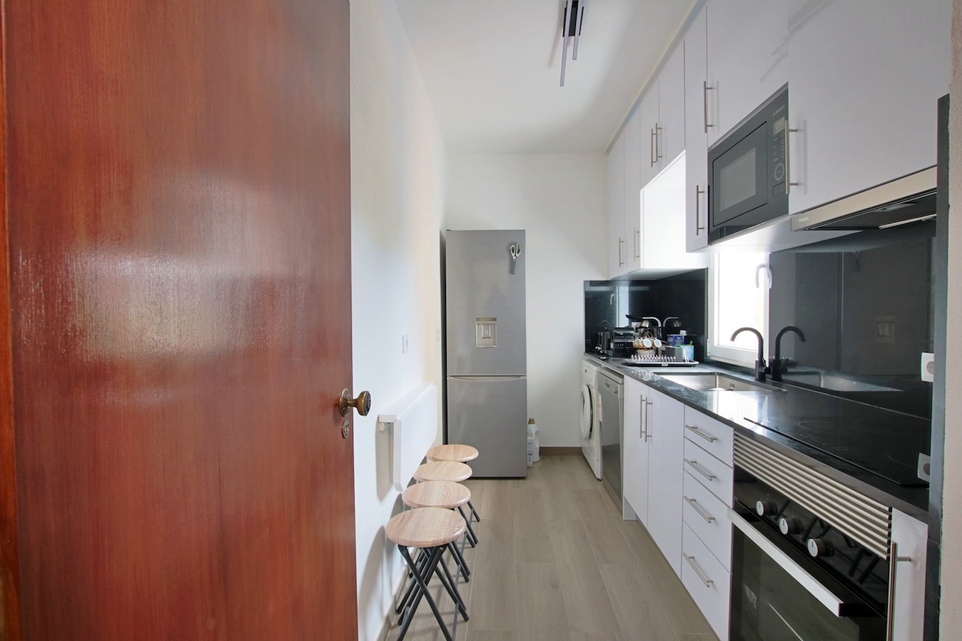 Entrance to kitchen with fridge, washing machine, dishwasher and oven