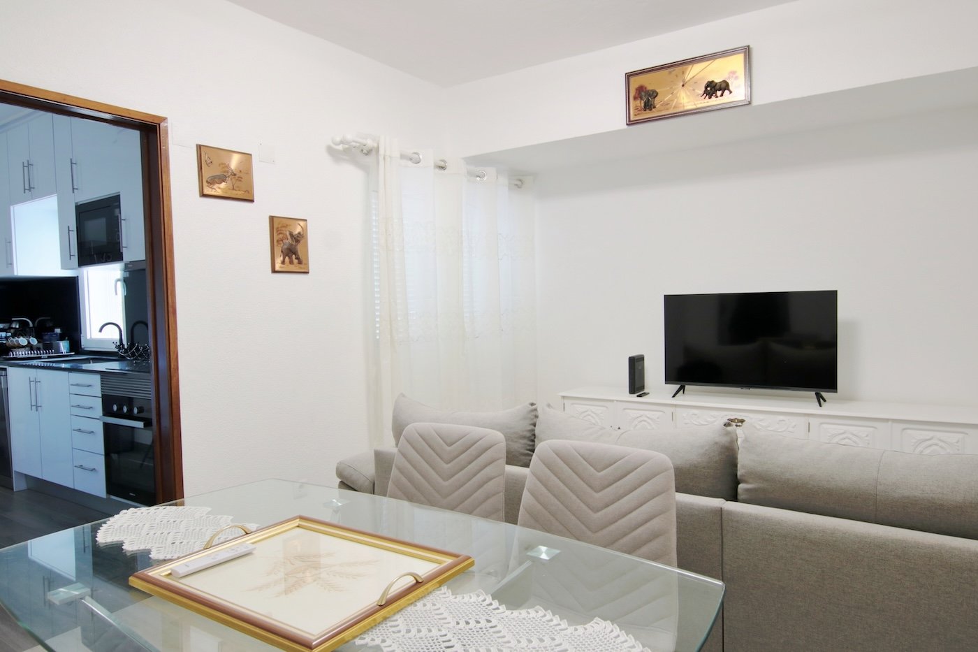 Living room whith table, chairs, sofa and view to the kitchen