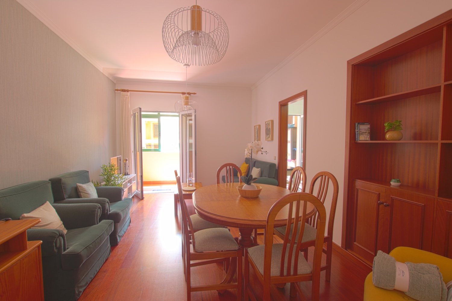 Living room with dining table, its chairs, armchairs, shelf, access to the veranda and to kitchen