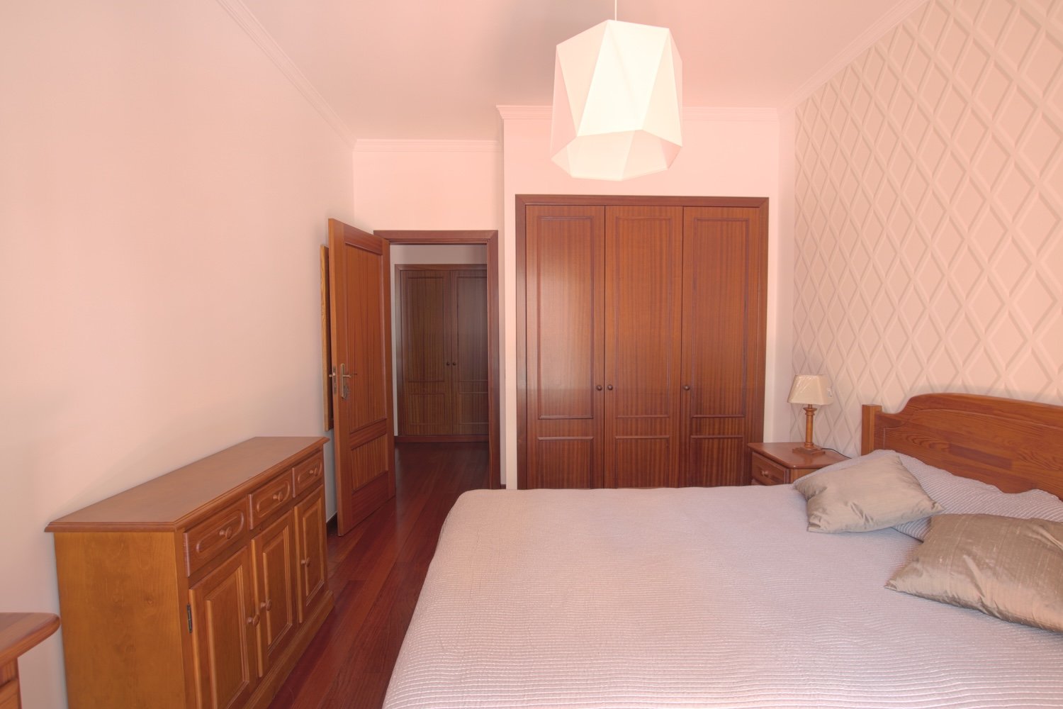 The bedroom with a sideboard, a double bed and a closet