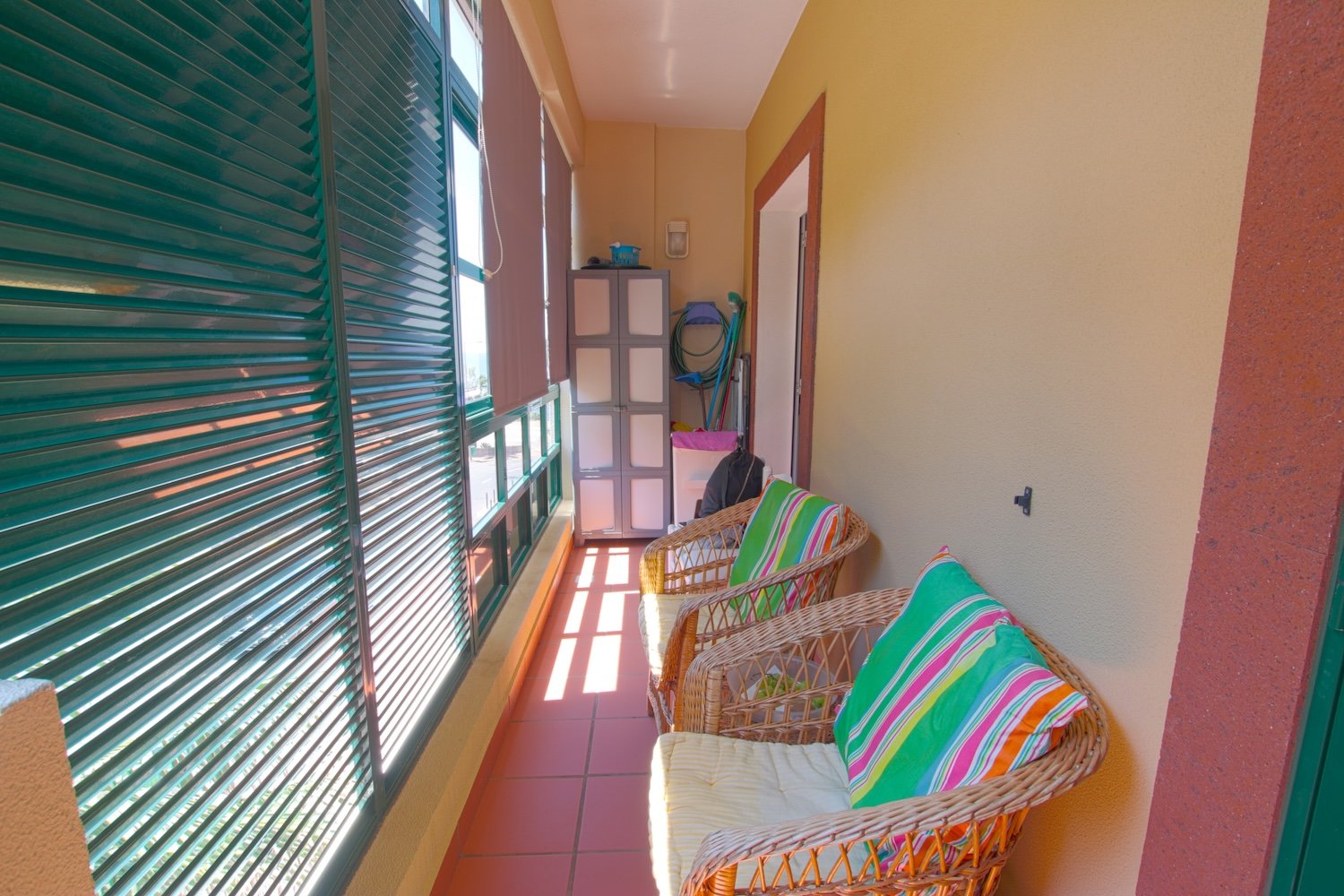 The main veranda with two armchairs a sink and a closed shelf